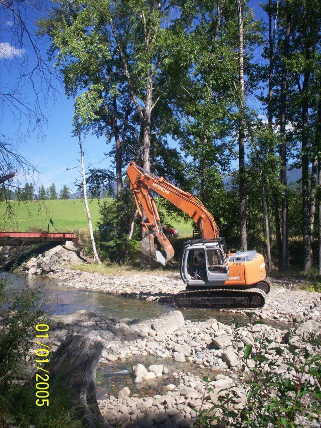 Excavator placing material in a stream channel near a crossing Excavator placing material in a stream channel near a crossing